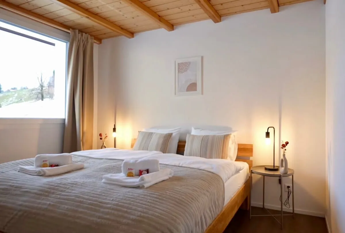 Schlafzimmer mit grossem Doppelbett und Schafberg-Blick
